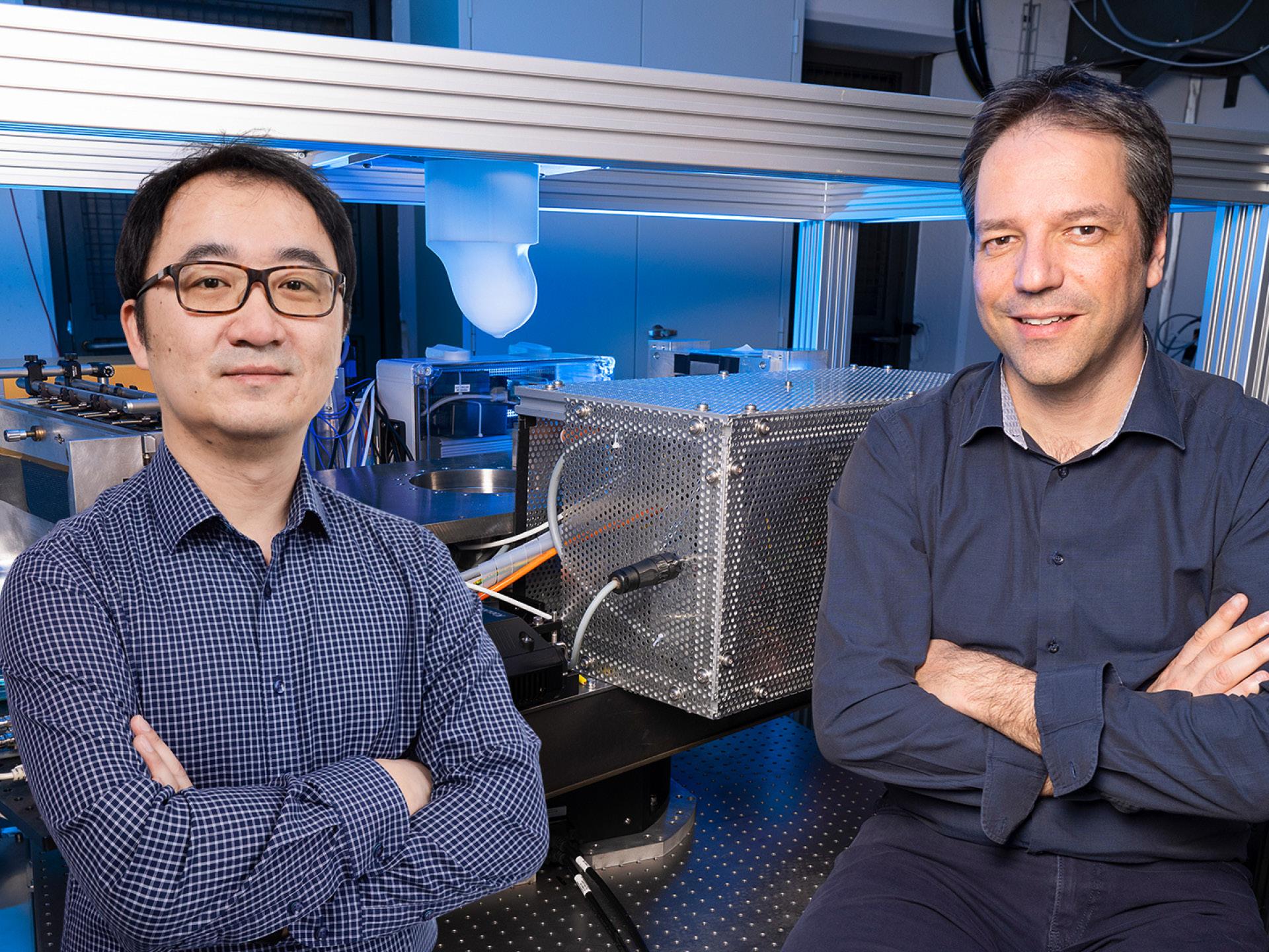 Marco Stampanoni and Zhentian Wang with blue shirts in their laboratory, smiling at camera with crossed arms